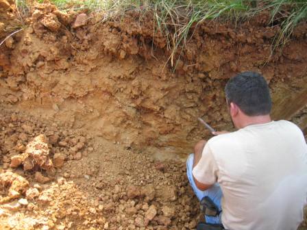 An EHS evaluating soil in a pit
