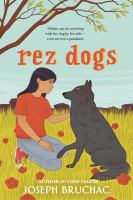 Cover of Rez Dogs. Young woman in red shirt and jeans, petting a gray dog. Field and tree in background.