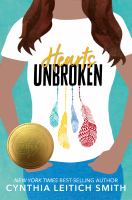 Cover of Hearts Unbroken. Young woman - cut off image, so what you see is her white t-shirt with the title printed on it, with feathers below it in red, blue and yellow, a little bit of her brown hair on her shoulders, her arms and her hands in her blue jean pockets.