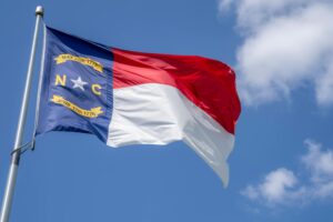 Photo of NC Flag - Photo by Mark Stebnicki: https://www.pexels.com/photo/north-carolina-flag-on-a-pole-under-blue-sky-9407524/