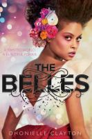 Cover of The Belles. Young woman looking over her shoulder, with flowers in her hair, in a white dress. She's not smiling.