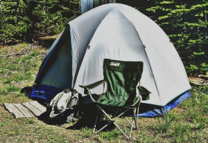 photo of a camping tent and chair with backpack