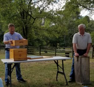 photo of presenters with antique plank bee gum and modern bee box