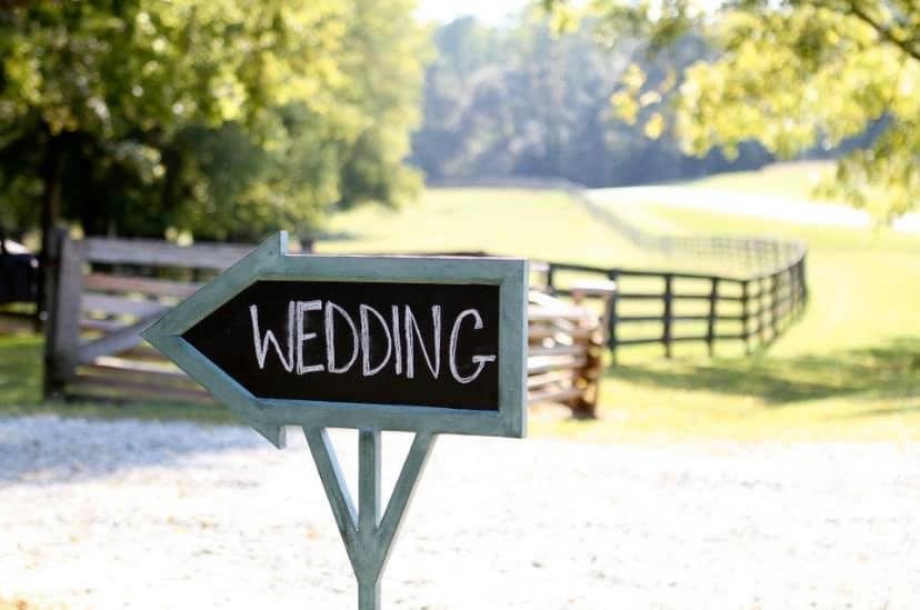An arrow sign with the word "wedding" in front of the Cedarock Park Historic Farm