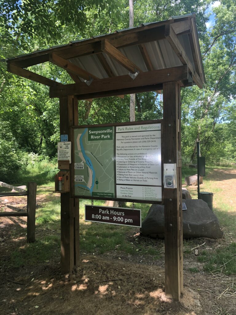 A kiosk with park signage at the entrance of Swepsonville River Park