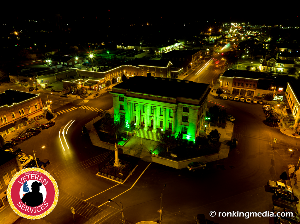 Aerial photo of downtown Graham with the historic Alamance County Courthouse illuminated green for Operation Green Light